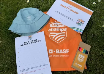 a orange bag with coloured pencils, a certificate, a pledge and a light blue hat